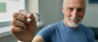 individual holding hearing aid